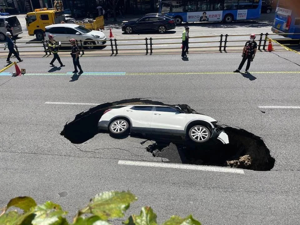 A car is seen after falling into a sinkhole that suddenly opened on a road in Seodaemun-gu, western Seoul, in August 2024. (Reddit)