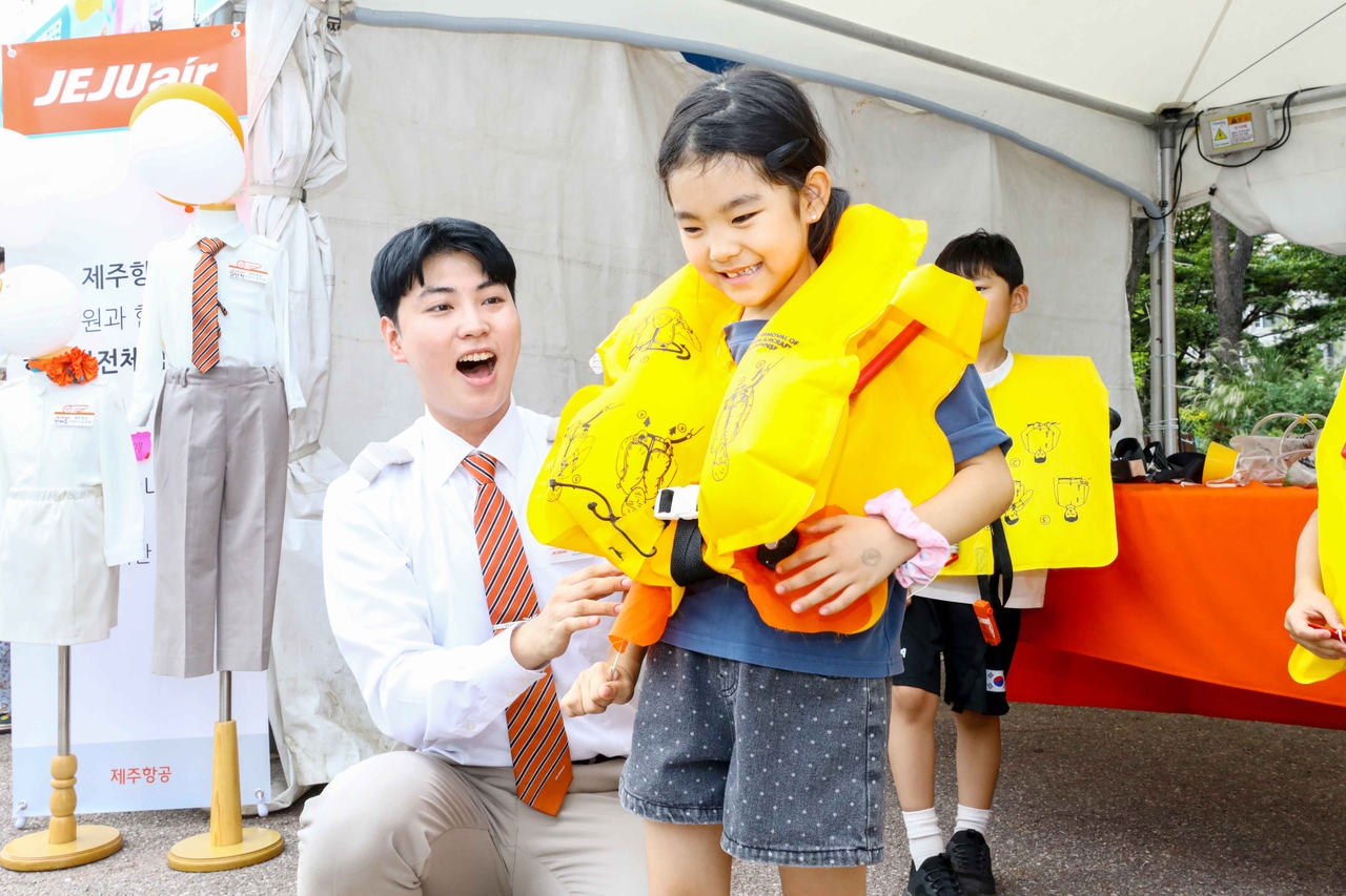 Jeju Air cabin crew members conduct aviation safety education for children at the "2026 Seoul Safety Festival" held at Yeouido Park in Seoul on Thursday afternoon. [Jeju Air]