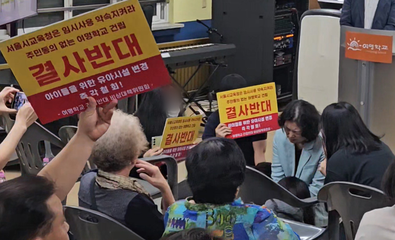 Yeomyung School principal Cho Myung-sook (second from right) kneels before residents on Friday during a town hall meeting held to gather opinions from residents about the Seoul Metropolitan Office of Education's plan to build a permanent campus for an alternative high school serving North Korean defectors in Gangseo-gu, Seoul. (Yonhap)