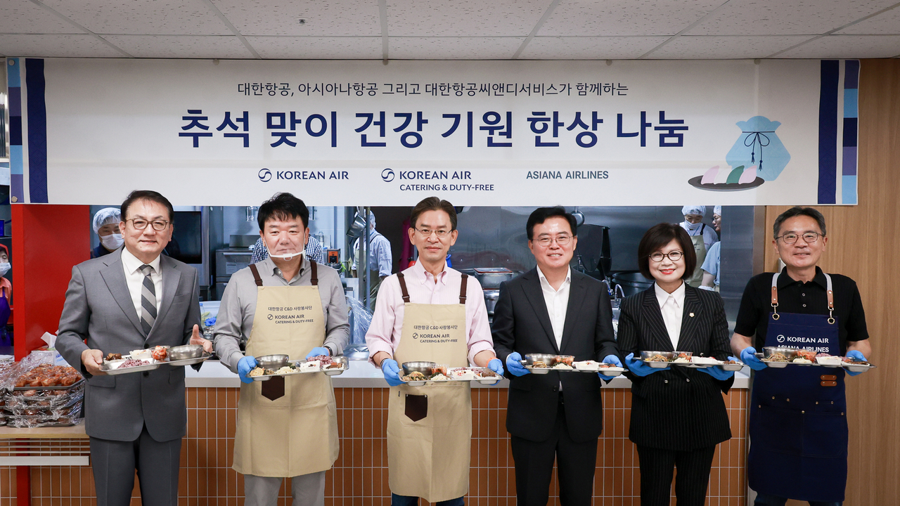Employees of Korean Air, Asiana Airlines and Korean Air C&D Services pose for a photo after taking part in a chuseok meal service for elderly residents. [Korean Air]