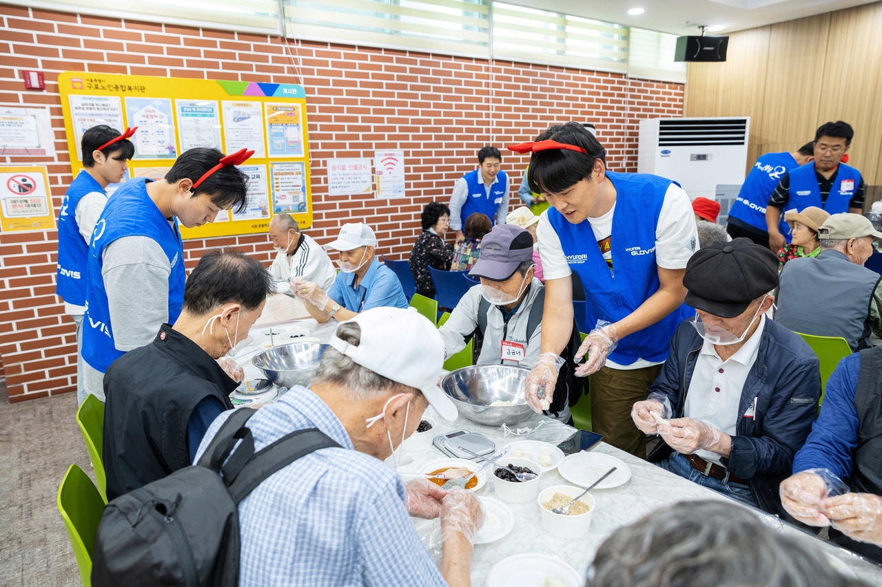 Hyundai Glovis employees make songpyeon rice cakes with elderly residents at the Guro Senior Welfare Center in Guro-gu, Seoul, on Thursday. [Hyundai Glovis]