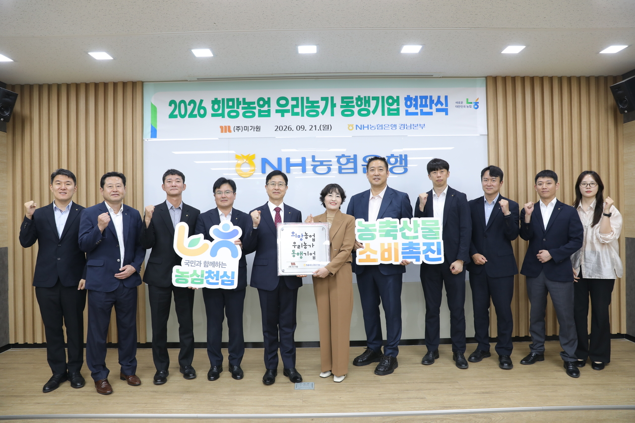 21일 농협은행 양산시지부에서 열린 ‘2026년 희망농업 우리농가 동행기업’ 현판식에서 권동현(왼쪽 네 번째) NH농협은행 경남본부장과 정영경(다섯 번째) ㈜미가원 대표 등 관계자들이 기념촬영을 하고 있다. [경남농협 제공]