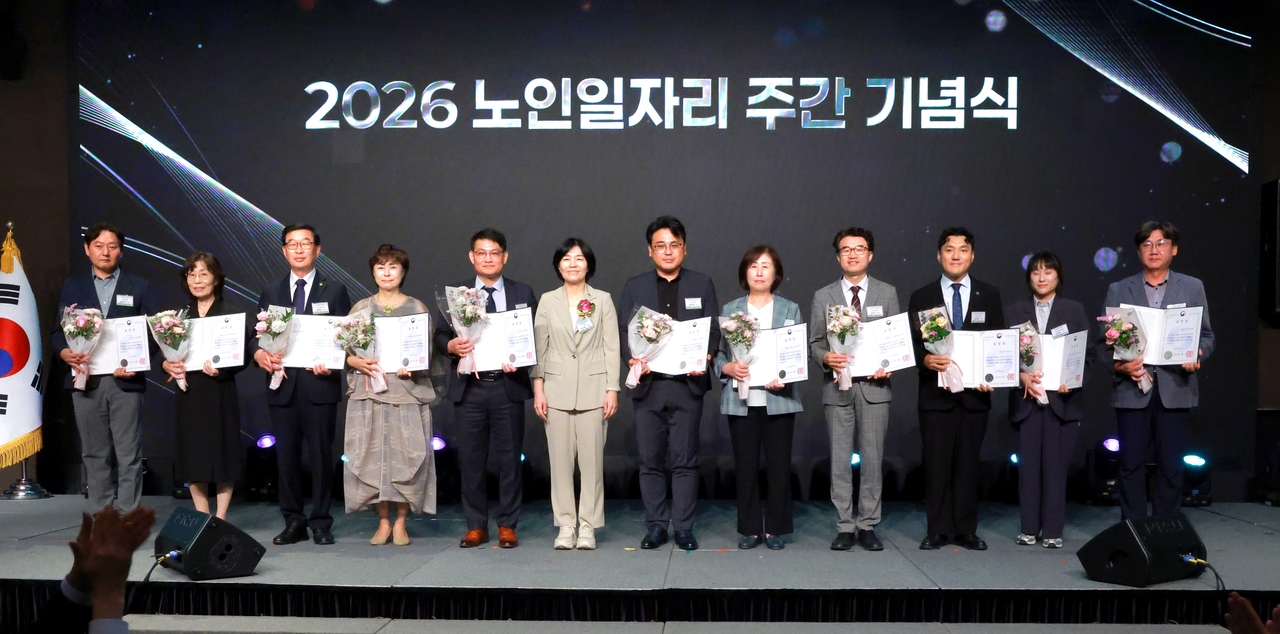 현수엽(사진 왼쪽에서 여섯 번째) 보건복지부 제1차관이 21일 서울 중구 더플라자호텔에서 열린 ‘2026 노인일자리 주간 기념식’에서 유공자들과 기념 촬영을 하고 있다. [보건복지부 제공]