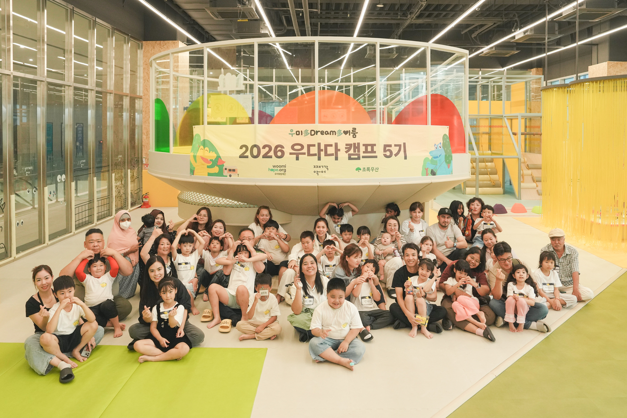 The Woomi Hope Foundation poses for a commemorative photo at the 2026 Udada Gyeonggi Camp for children from multicultural families at Jjaekkakssom Hanam on Saturday. [Woomi Hope Foundation]