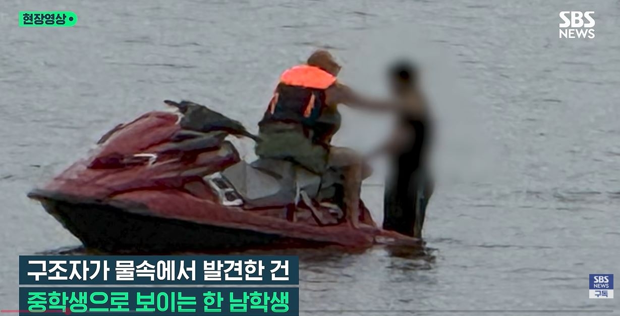 This screengrab of SBS' news coverage shows Michael Blunck (left) pulling out a high school student from the Hangang River on Sept. 14. (Official YouTube channel of SBS)