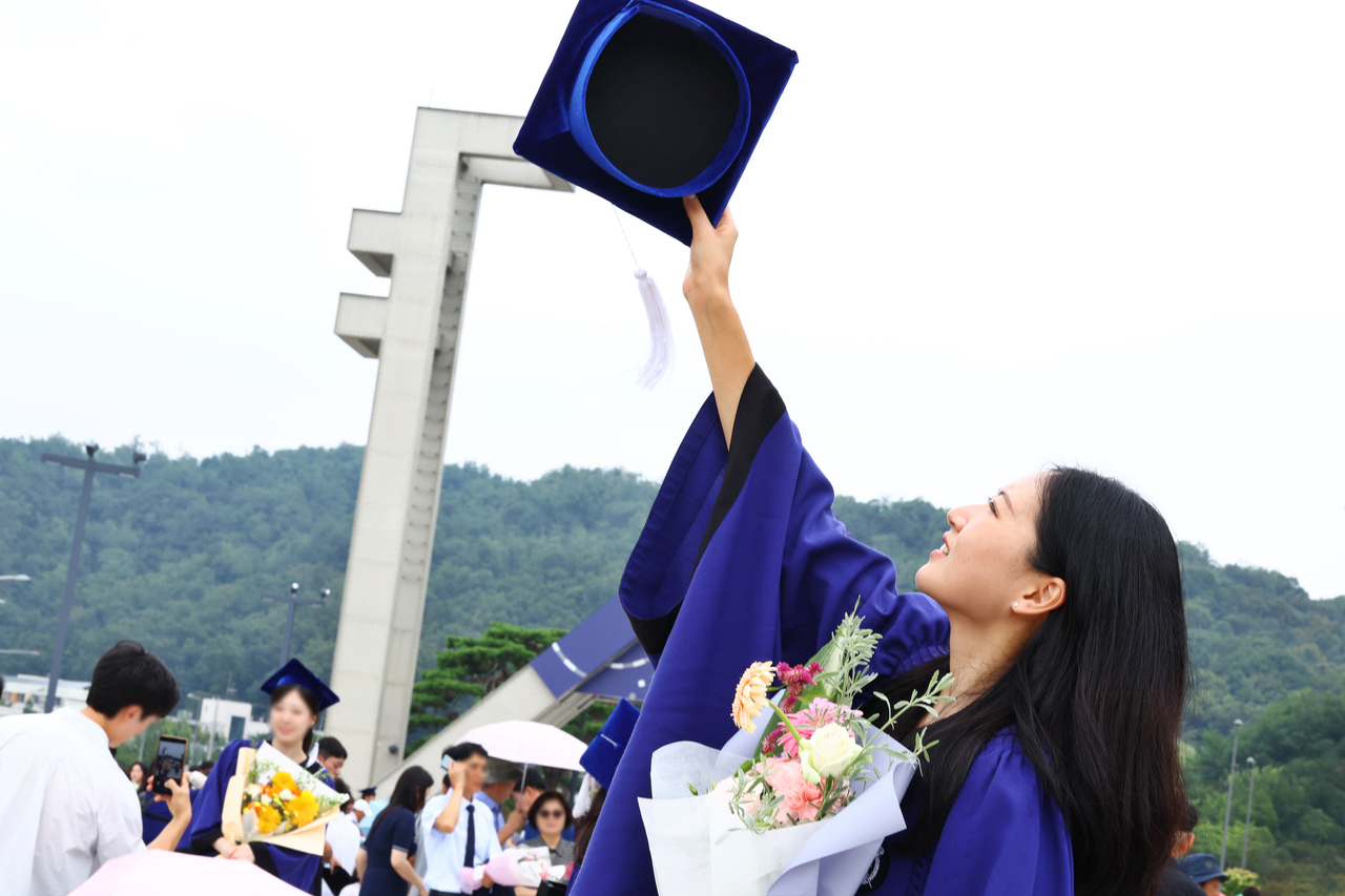 A Seoul National University student throws their cap into the air after the university's 80th commencement ceremony at its Gwanak Campus in Gwanak-gu, Seoul, on Aug. 28. (Yonhap)