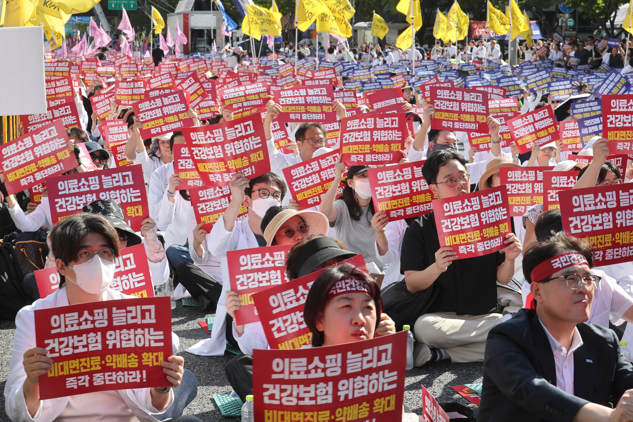 20일 서울 종로구 동화면세점 앞에서 열린 ‘전국약사 총궐기대회’에서 참가자들이 요구가 담긴 손팻말을 들고 있다. <연합뉴스>