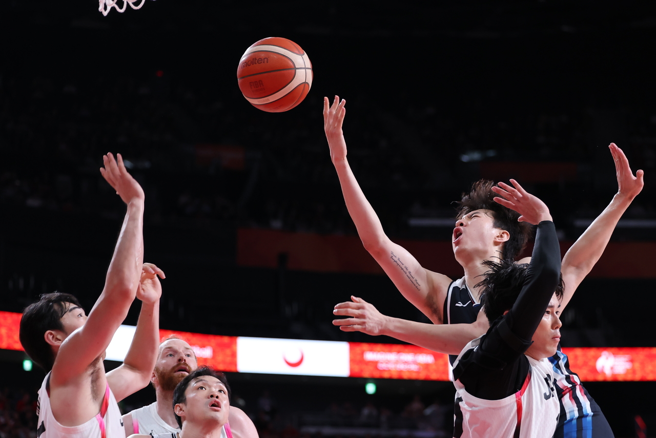 South Korea’s Lee Hyun-jung (second from right)  fights for the ball during the men’s basketball final against Japan at the 2026 Aichi-Nagoya Asian Games at Aichi International Arena in Nagoya, Japan, on Sunday. (Yonhap)