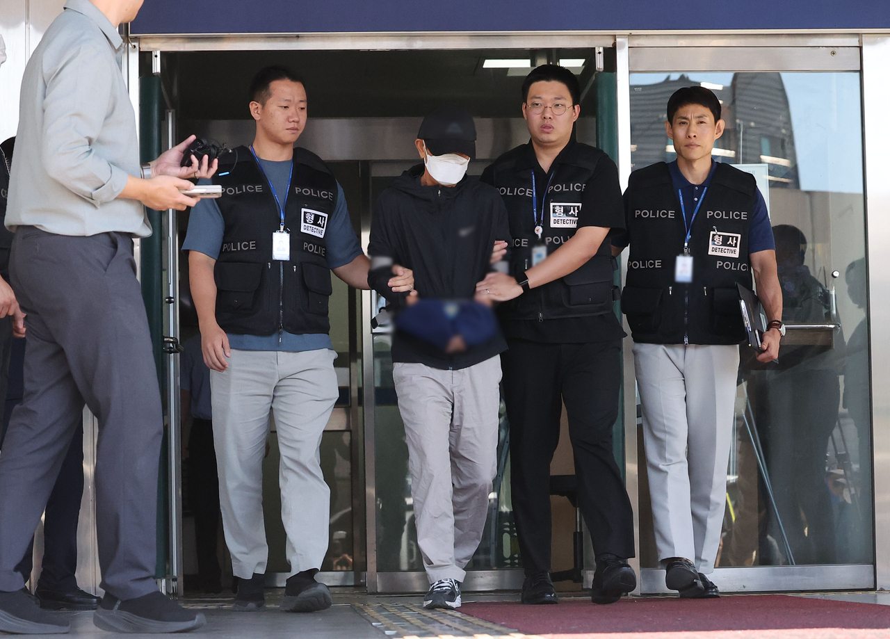 경기 안성시 나눔장터 행사장에 1t 트럭을 몰고 돌진해 2명을 숨지게 하고 5명을 다치게 한 혐의를 받는 운전자 A씨가 21일 모자와 마스크를 쓴 채 고개를 숙이며 경기 평택경찰서 유치장에서 나오고 있다. [연합]