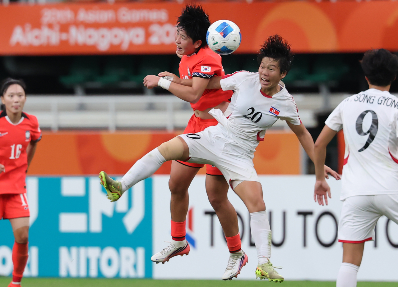 South Korea's Kim Min-ji (left) and North Korea's Chae Un-yong are fighting for the ball during the inter-Korean match Monday. (Yonhap)