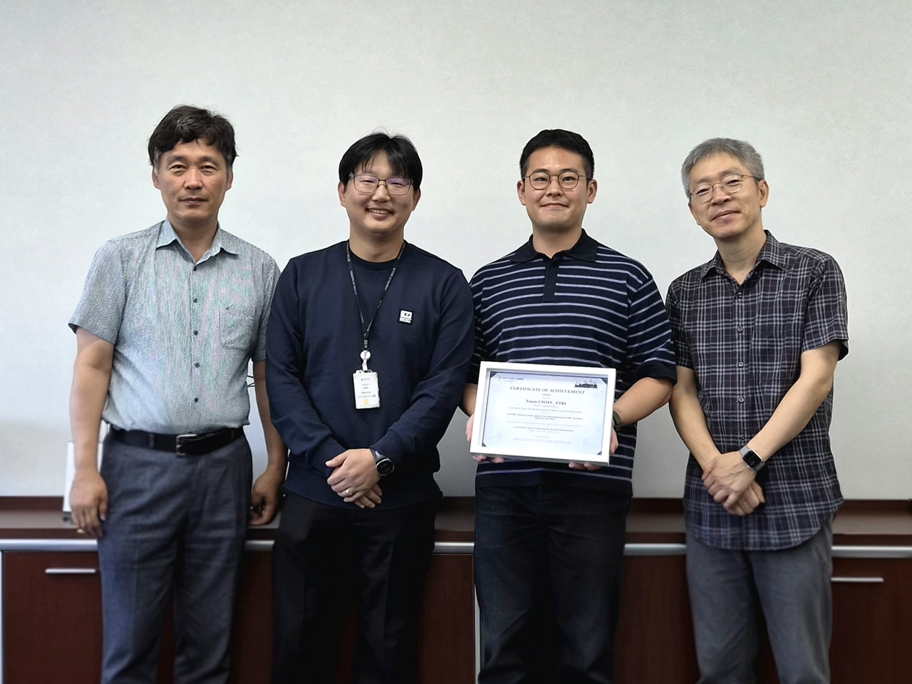ETRI took first and second place in two categories at the 10th AI City Challenge. From left: Byeon Woo-jin, head of ETRI's Daegyeong Regional Research Division; Kim Gwang-ju, division director; researcher Kim Sang-won; and senior researcher Kim Byeong-geun. [ETRI]