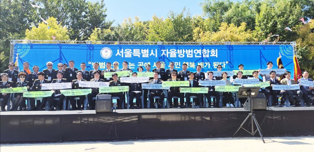 Participants pose for a group photo at the Seoul Metropolitan Government Volunteer Crime Prevention Federation's skills competition held in Yeouido, Seoul, on Saturday.