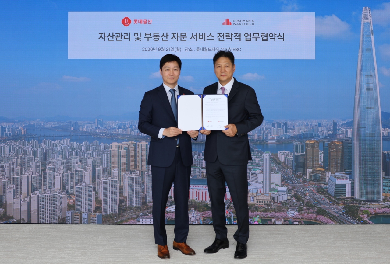 장재훈(왼쪽) 롯데물산 대표이사와 황점상 쿠시먼앤드웨이크필드 코리아 대표가 롯데월드타워 113층 EBC에서 열린 업무협약식에서 기념 촬영을 하고 있다. [롯데물산 제공]