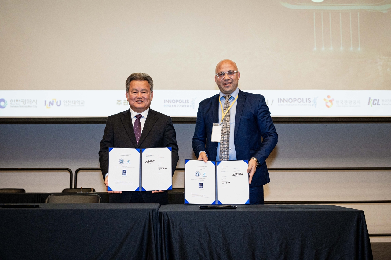 Professor Lee Hee-kwan (left) of Incheon National University and professor Karim Abdelrazek Elsayed Emara of Capital University in Egypt pose for a photo after signing a memorandum of understanding. (Incheon Innovation Cluster)