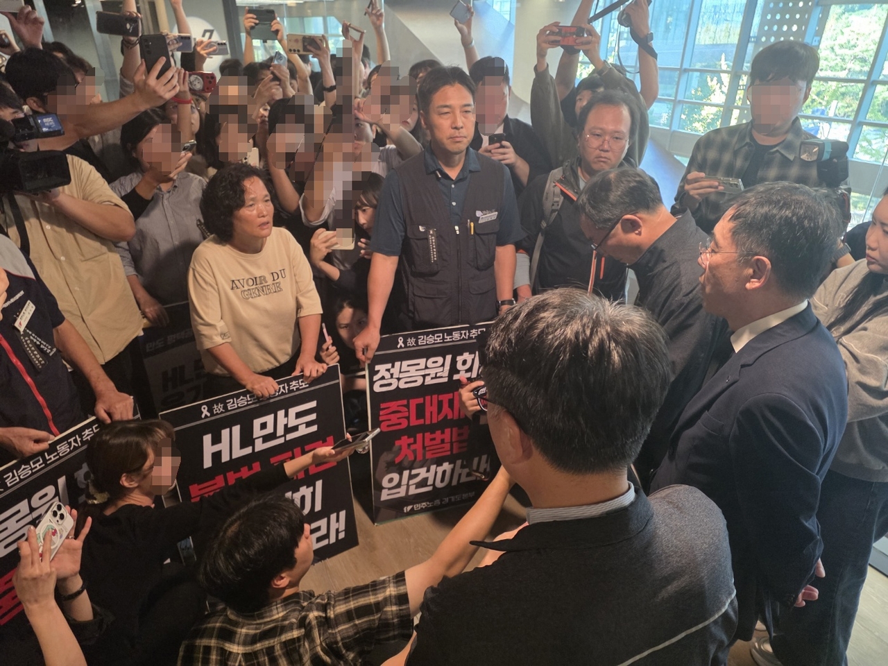21일 경기 성남시 판교 사옥에서 고(故) 김승모씨 중대재해 대책위원회 관계자들이 대국민 사과 성명 및 종합안전개선대책 발표 기자회견에 반발하며 조성현 HL만도 부회장과 대치하고 있다. 서재근 기자