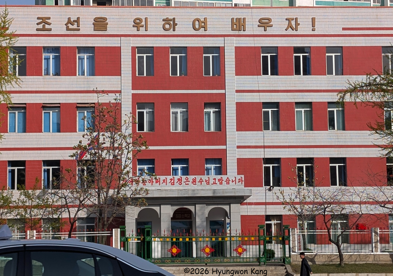 The slogan “Let us learn for Chosun!”is displayed in the largest letters at the top of a four-story school building in Pyongyang on April 19. (Hyungwon Kang)