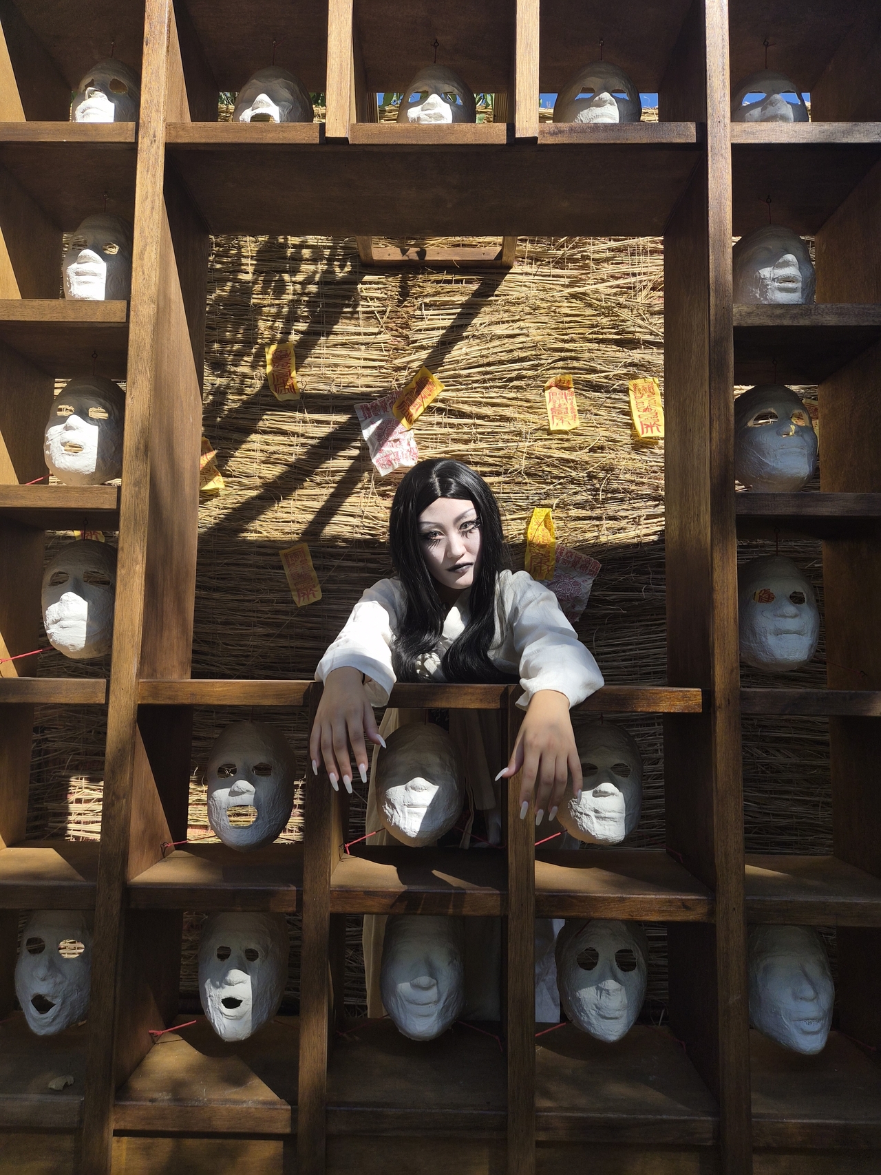 Kang Yoon-jung, who plays a virgin ghost at the Korean Folk Village in Yongin, Gyeonggi Province, poses in front of a building decorated with traditional Korean demon-face motifs on Sept. 15. (Choi Jae-hee / The Korea Herald)
