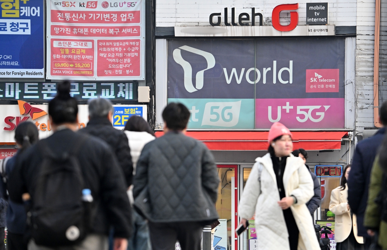 People walk past a mobile carrier agency of SK Telecom on Dec. 29, 2025. (Im Se-jun/The Korea Herald)