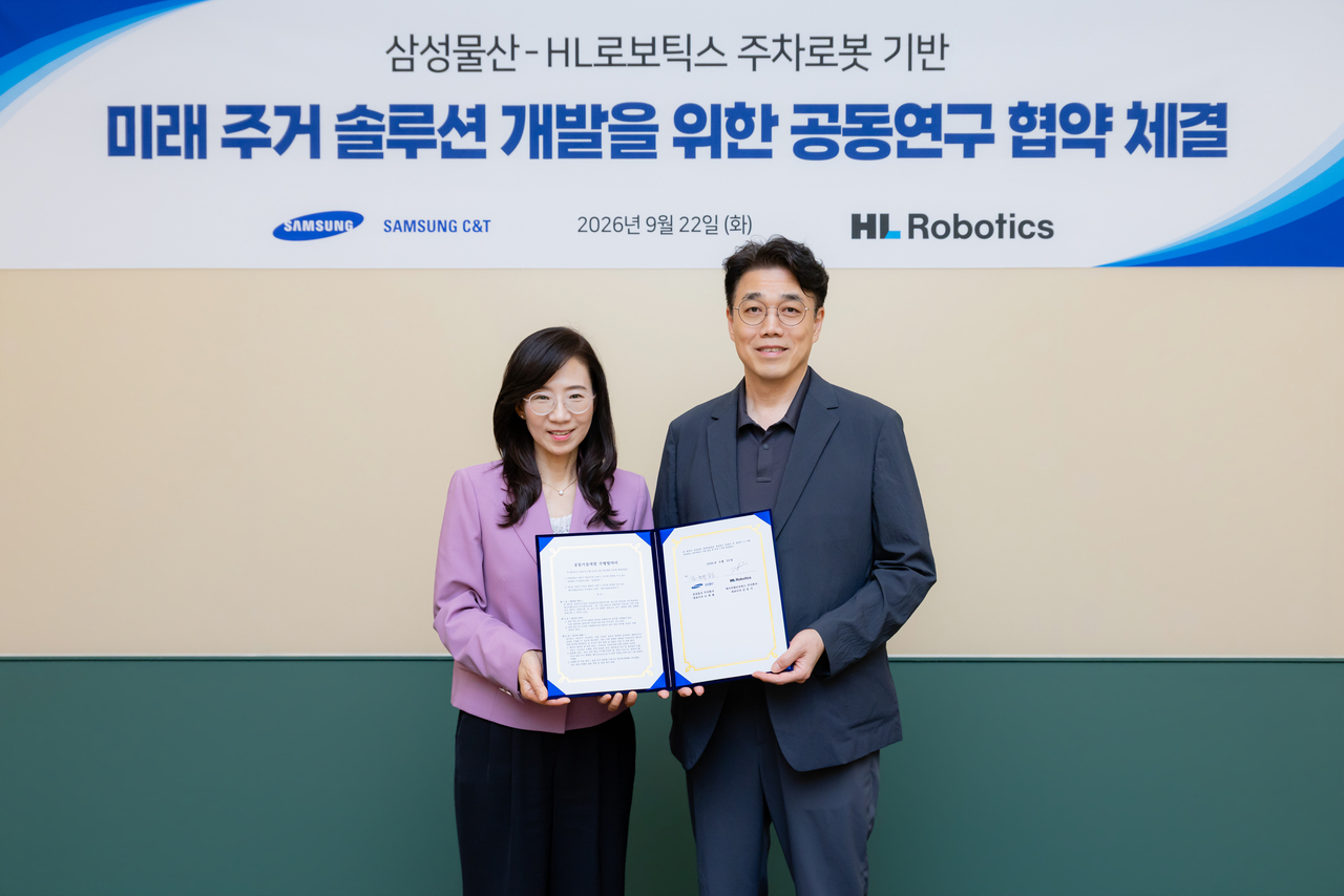 HL Robotics CEO Kim Yun-gi (right) and Samsung C&T Executive Vice President Cho Hye-jeong pose for a photo after signing an MOU at the Raemian Gallery in Songpa-gu, Seoul, on Tuesday. [HL Robotics]
