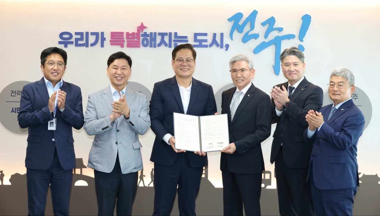 Woomi Construction holds a donation ceremony at Jeonju City Hall on Monday, with CEO Kim Young-gil (center right) and Jeonju Mayor Jo Ji-hun (center left) in attendance. [Woomi Construction]