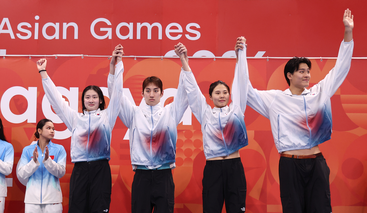 South Korea’s Kim Seung-won (from left), Choi Dong-yeol, An Se-hyeon and Kim Young-beom celebrate on the podium after winning bronze in the mixed 4x100-meter medley relay at the 2026 Aichi-Nagoya Asian Games at the Tokyo Aquatics Centre on Wednesday. (Yonhap)