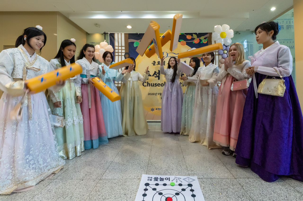 International students at Sookmyung Women's University play a Korean traditional board game called yut, during a cultural event held at the university's campus in Yongsan-gu, Seoul, Tuesday. (Sookmyung Women's University)