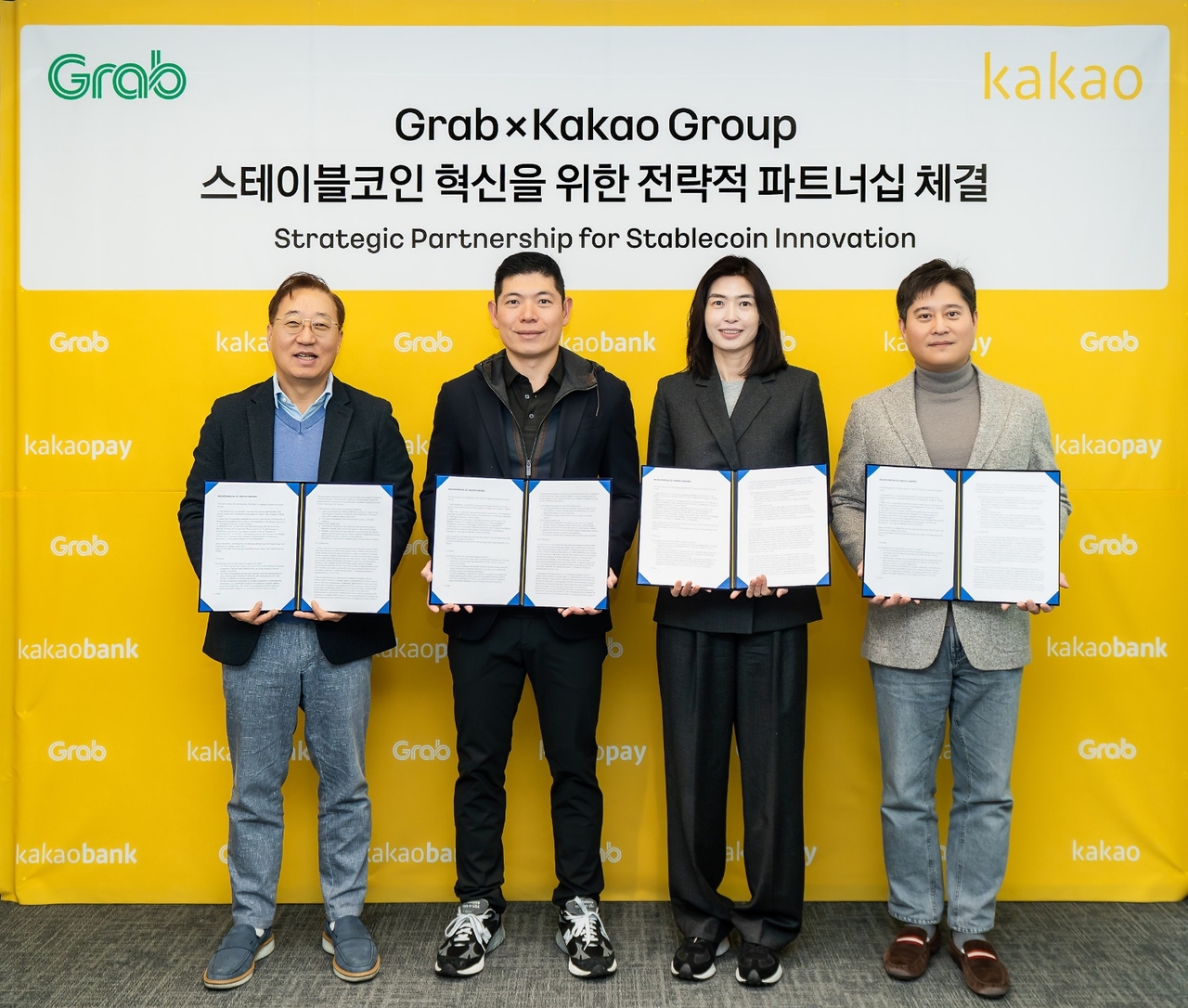 From left: Kakao Bank CEO Yun Ho-young, Grab CEO Anthony Tan, Kakao CEO Chung Shin-a and Kakao Pay CEO Shin Won-keun pose during a signing ceremony in December 2025. (Kakao Bank)