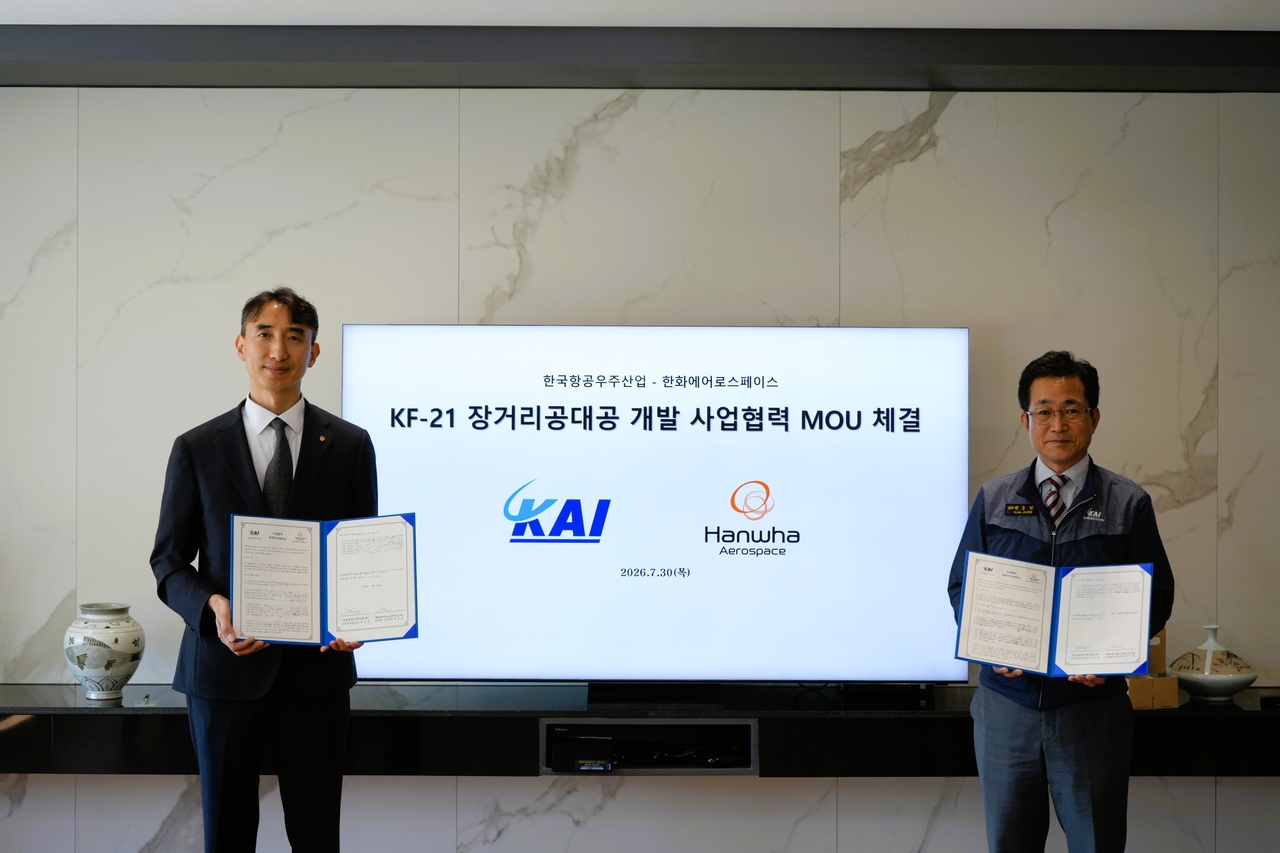 Baek Ki-bong (left), head of Hanwha Aerospace's PGM2 business division, and Baek Jung-hyun, head of Korea Aerospace Industries' fixed-wing business unit, pose for a photo at the MOU signing ceremony for the KF-21 long-range air-to-air missile development project at KAI's headquarters in Sacheon, South Gyeongsang Province, in July. [Hanwha Aerospace]