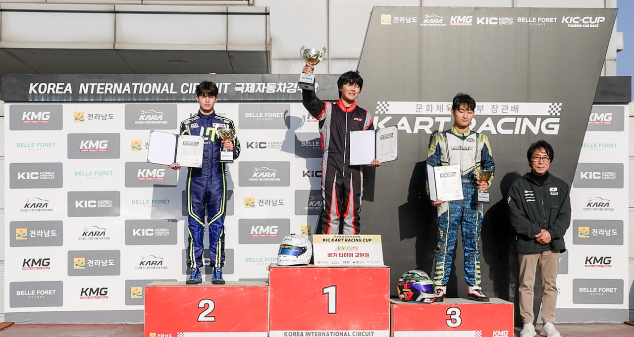 Middle school racer Lee Min-jae, center, stands atop the podium.
