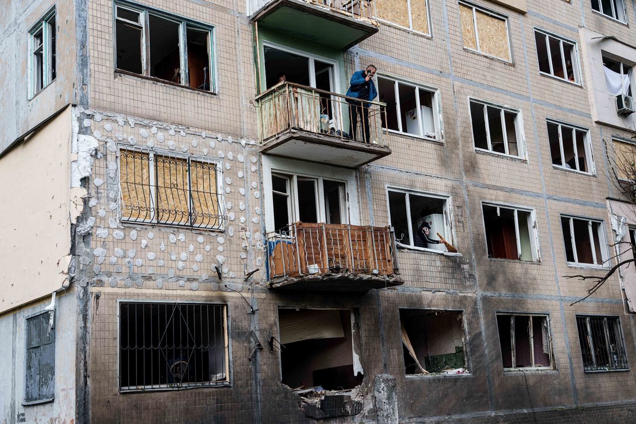 A man stands at a balcony of an apartment building damaged after a Russian drone strike in Kyiv, Ukraine, Tuesday. (AP-Yonhap)