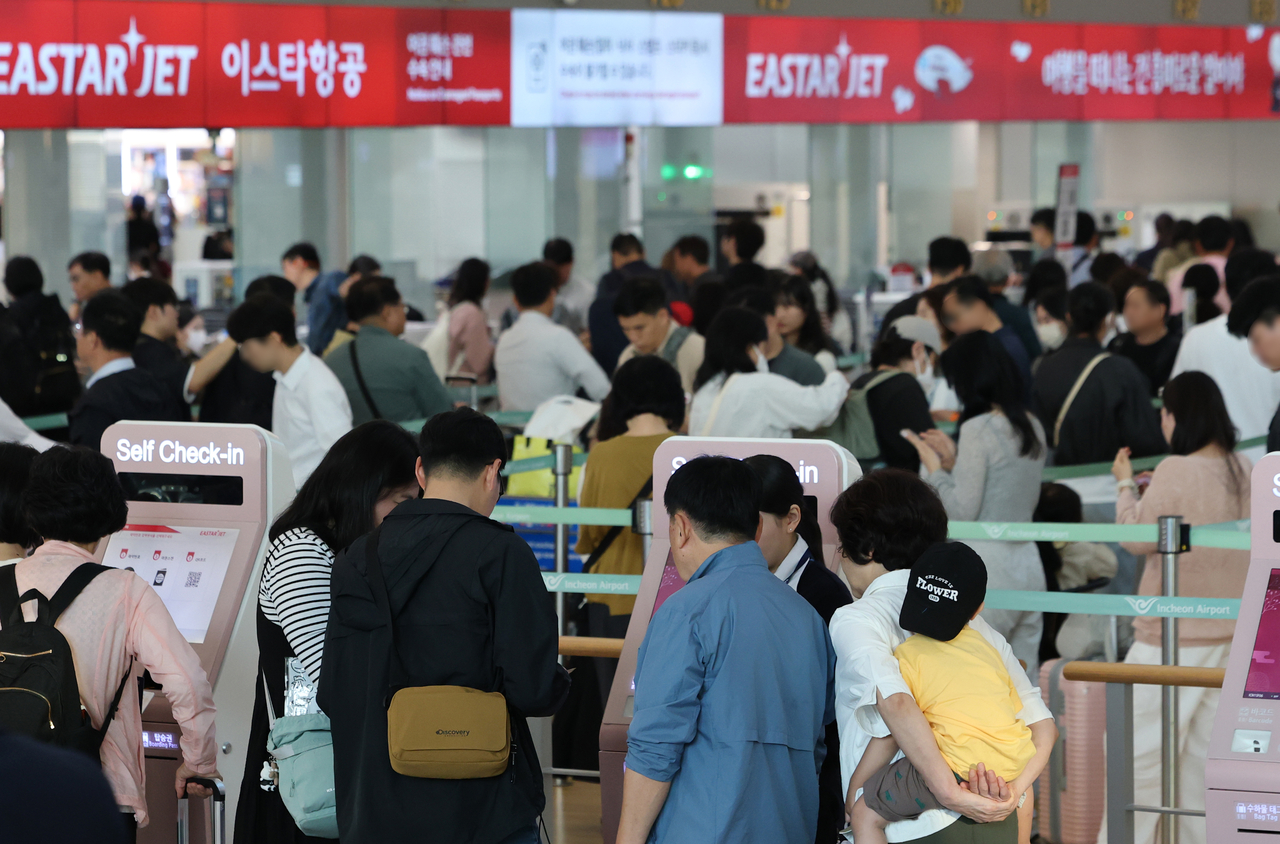 Travelers wait to check in at Terminal 1 of Incheon Airport on Wednesday, a day before the Chuseok holiday begins. (Yonhap)
