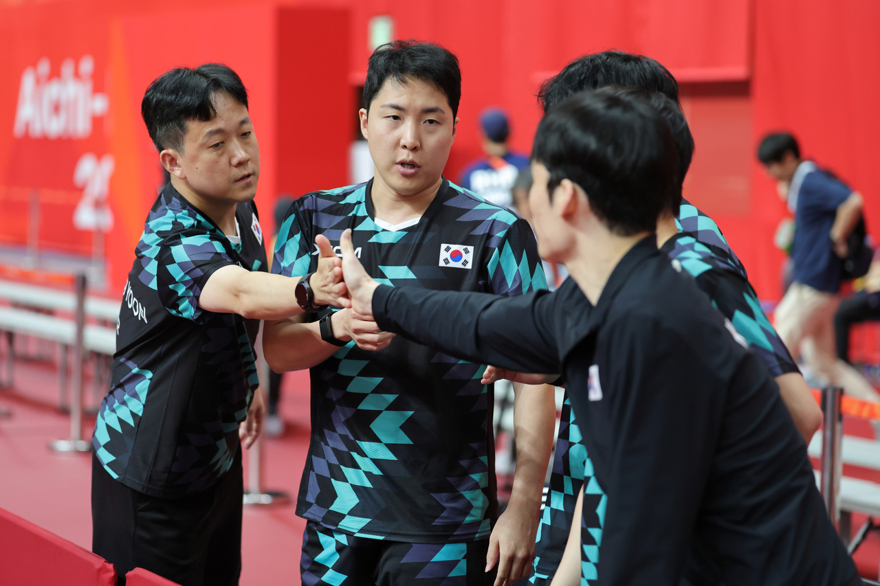 23일 일본 아이치현 스카이홀에서 열린 2026 아이치·나고야 아시안게임 탁구 남자단체 준결승 대한민국과 일본의 경기에서 패한 뒤 대한민국 윤재영 코치와 선수들이 서로 격려하고 있다. [연합]