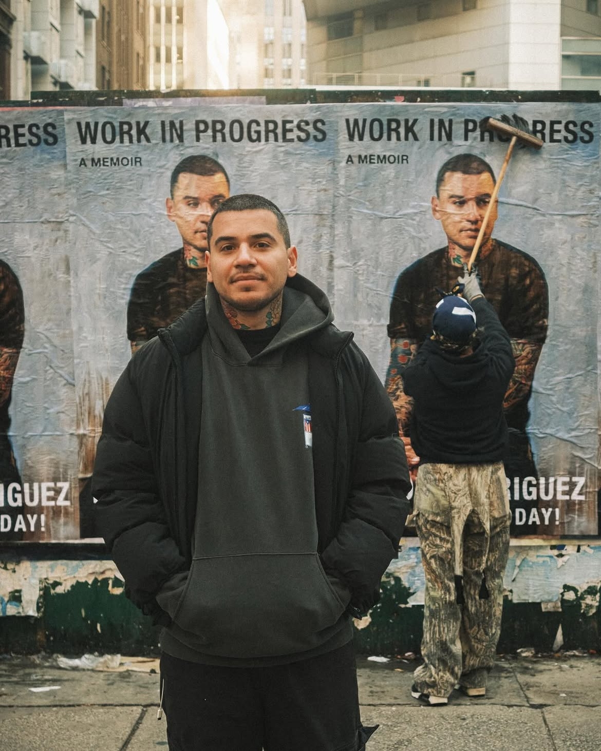Rodriguez stands in front of posters for his memoir, "Work in Progress." (@devonrodriguezart, Instagram)