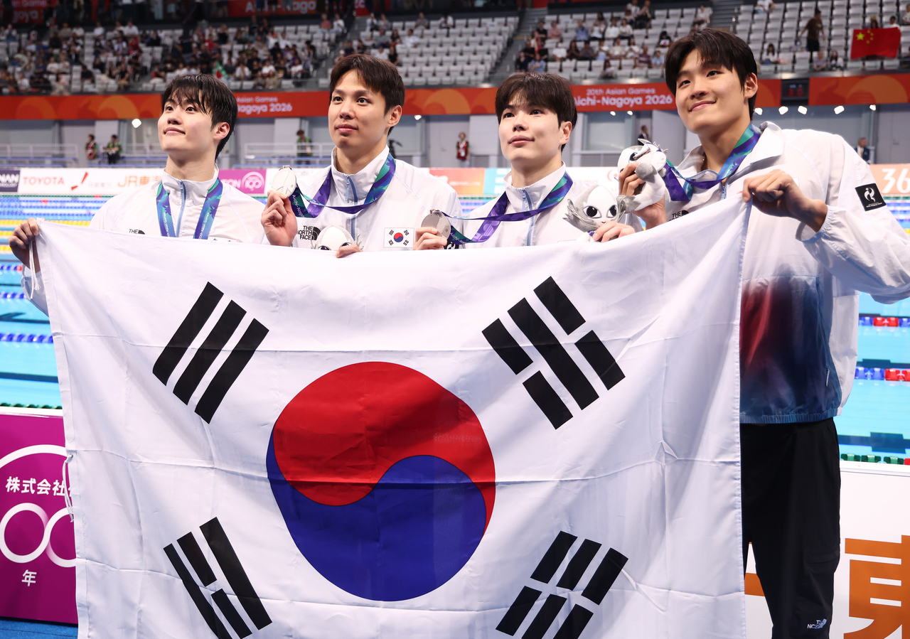 24일 도쿄 아쿠아틱스 센터에서 열린 2026 아이치·나고야 아시안게임 수영 남자 400m 자유형 계영 결승에서 은메달을 따낸 대한민국 선수들이 태극기를 들고 포즈를 취하고 있다. 왼쪽부터 황선우, 양재훈, 김지훈, 김영범. [연합]