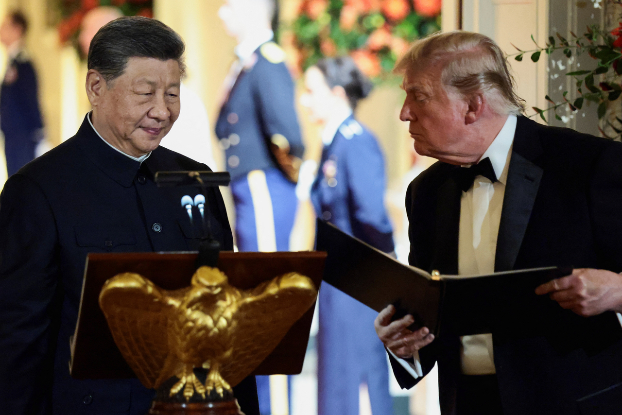 US President Donald Trump holds a binder as he stands next to Chinese President Xi Jinping before Xi delivers a speech during a state dinner at the White House in Washington. (Yonhap- Reuters)