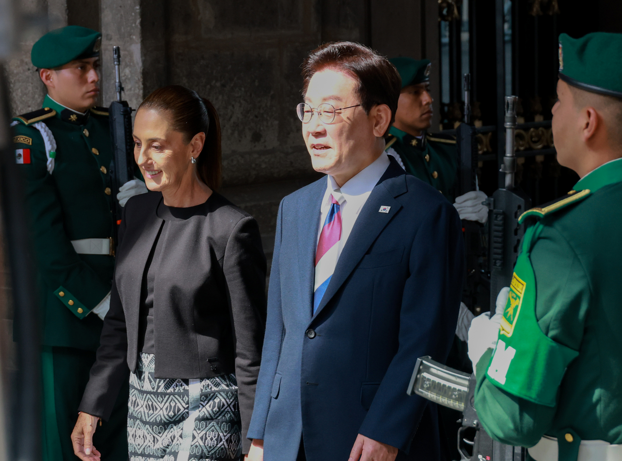 President Lee Jae Myung walks alongside Mexican President Claudia Sheinbaum during an official welcoming ceremony at the National Palace in Mexico City on Thursday (local time), as Lee makes a state visit to Mexico. [Yonhap]