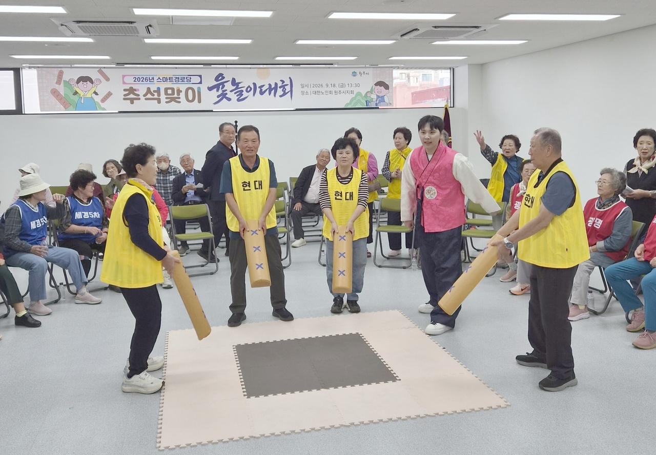 Four-person teams cooperate to throw the oversized yut sticks during the tournament.