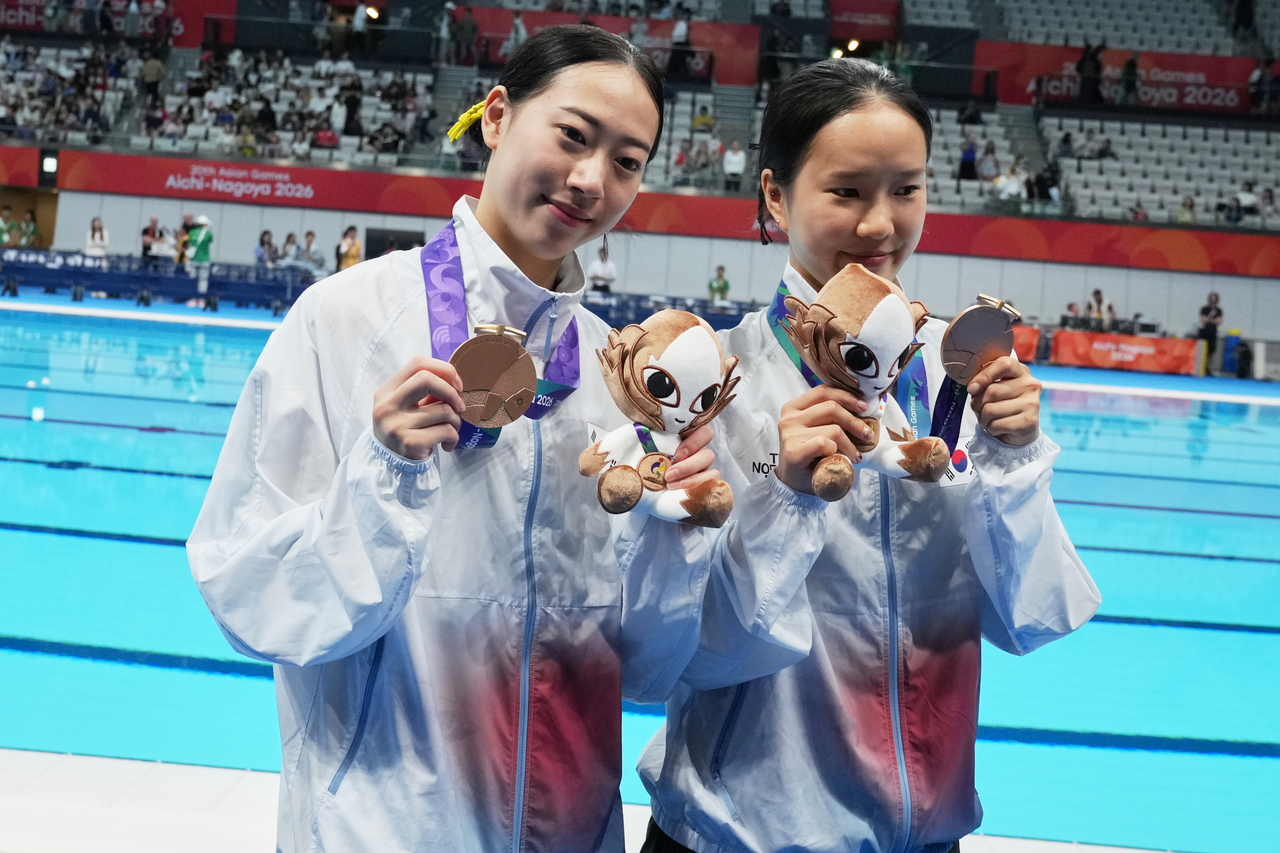 Bronze medalists Kim Na-hyun and Moon Na-yun of South Korea pose with their medals after the women's synchronized 10m platform final at the Asian Games in Tokyo, Japan, Saturday. (AP-Yonhap)