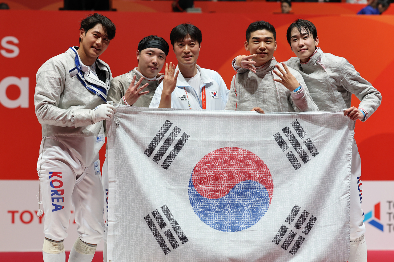 26일 일본 아이치현 도코나메 아이치 스카이 엑스포에서 열린 2026 아이치·나고야 아시안게임 펜싱 남자 사브르 단체 한국과 일본의 결승.  승리를 거둔 대한민국 선수들이 태극기를 들고 기념촬영을 하고 있다. [연합]