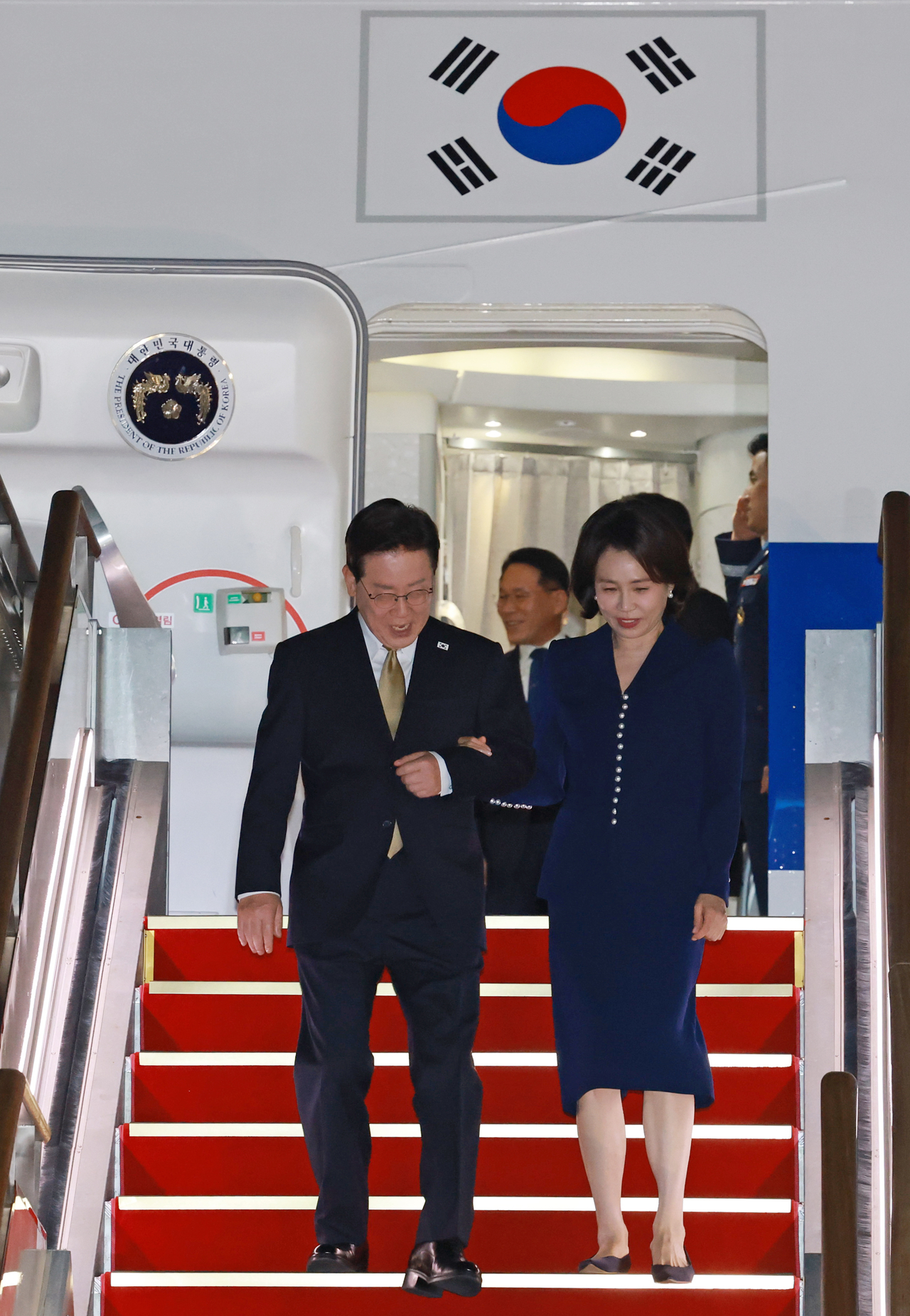 President Lee Jae Myung (left) and first lady Kim Hea Kyung disembark from the presidential jet at Seoul Air Base in Seongnam, Gyeonggi Province, on Sunday, after returning from a trip to the US and Mexico. (Yonhap)