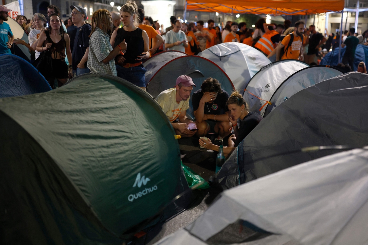 Demonstrators sit next to tents as they camp during a protest against evictions and the housing crisis in Madrid on Saturday. (AFP-Yonhap)