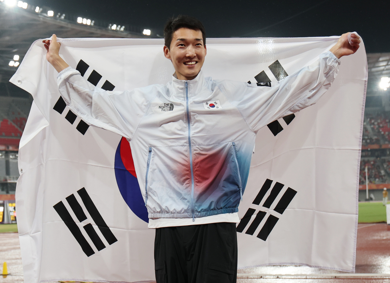 27일 일본 아이치현 나고야 미즈호 공원 육상 경기장에서 열린 2026 아이치·나고야 아시안게임 육상 남자 높이뛰기 결승. 한국 우상혁이 동메달을 획득한 뒤 태극기를 들고 있다. [연합]
