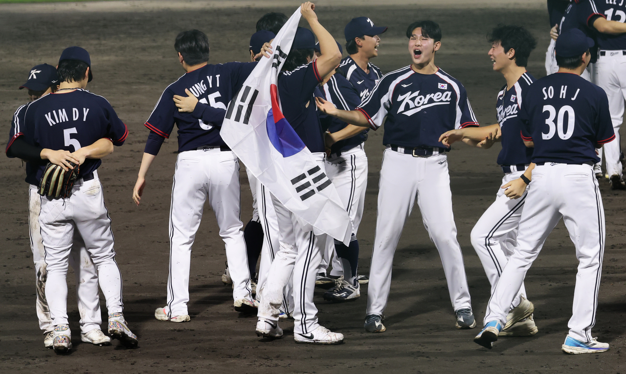 27일 일본 아이치현 도요하시 시민구장에서 열린 2026 아이치·나고야 아시안게임 결승 한국과 일본의 경기. 3-1로 승리하고 금메달을 차지한 한국 선수들이 태극기를 들고 기뻐하고 있다. [연합]
