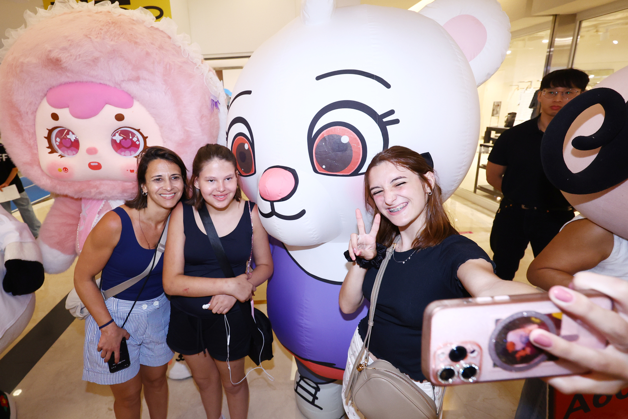 Foreign tourists pose for photos with character mascots. [Yonhap]