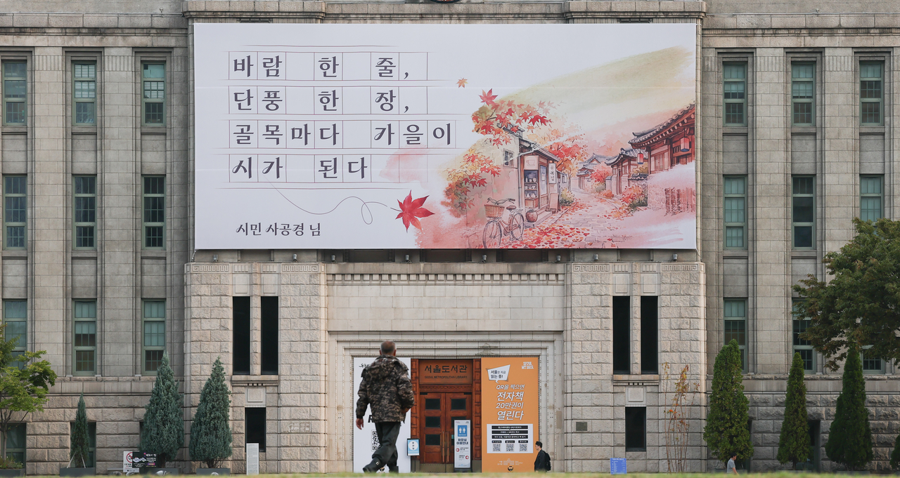 28일 오전 서울 중구 서울도서관 외벽 서울꿈새김판이 가을편 문구로 새롭게 바뀌어 있다. 가을편은 ‘바람 한 줄, 단풍 한 장, 골목마다 가을이 시가 된다’라는 문안과 함께 단풍과 서울의 골목길을 수채화풍으로 표현했다. 윤창빈 기자