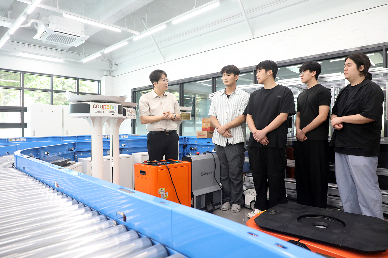 Professor Seong Geum-gil explains an AI-based logistics automation system to students at the AI Logistics Education Center. [Yeungnam University of Science and Technology]