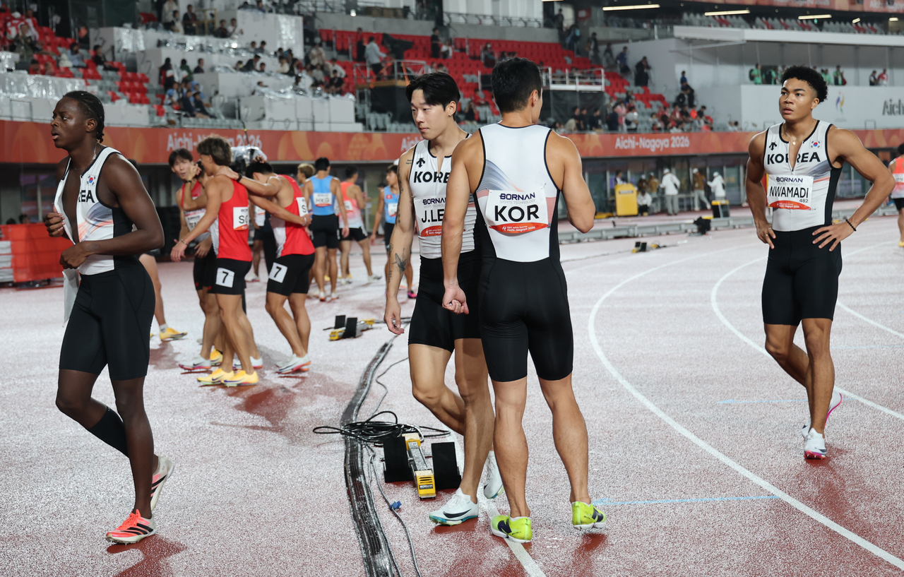 South Korea's 4x100-meter relay team leaves the track after being disqualified during the heats of the men's 4x100-meter relay on Sunday. (Yonhap)