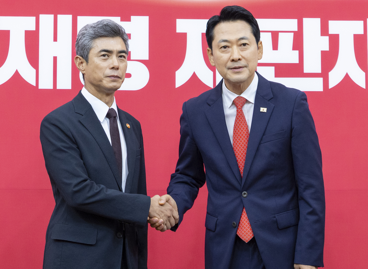 장동혁 국민의힘 대표(오른쪽)가 취임 인사를 위해 국민의힘을 찾은 강신철 국방부 장관과 28일 국회에서 만나 악수하고 있다. [연합]