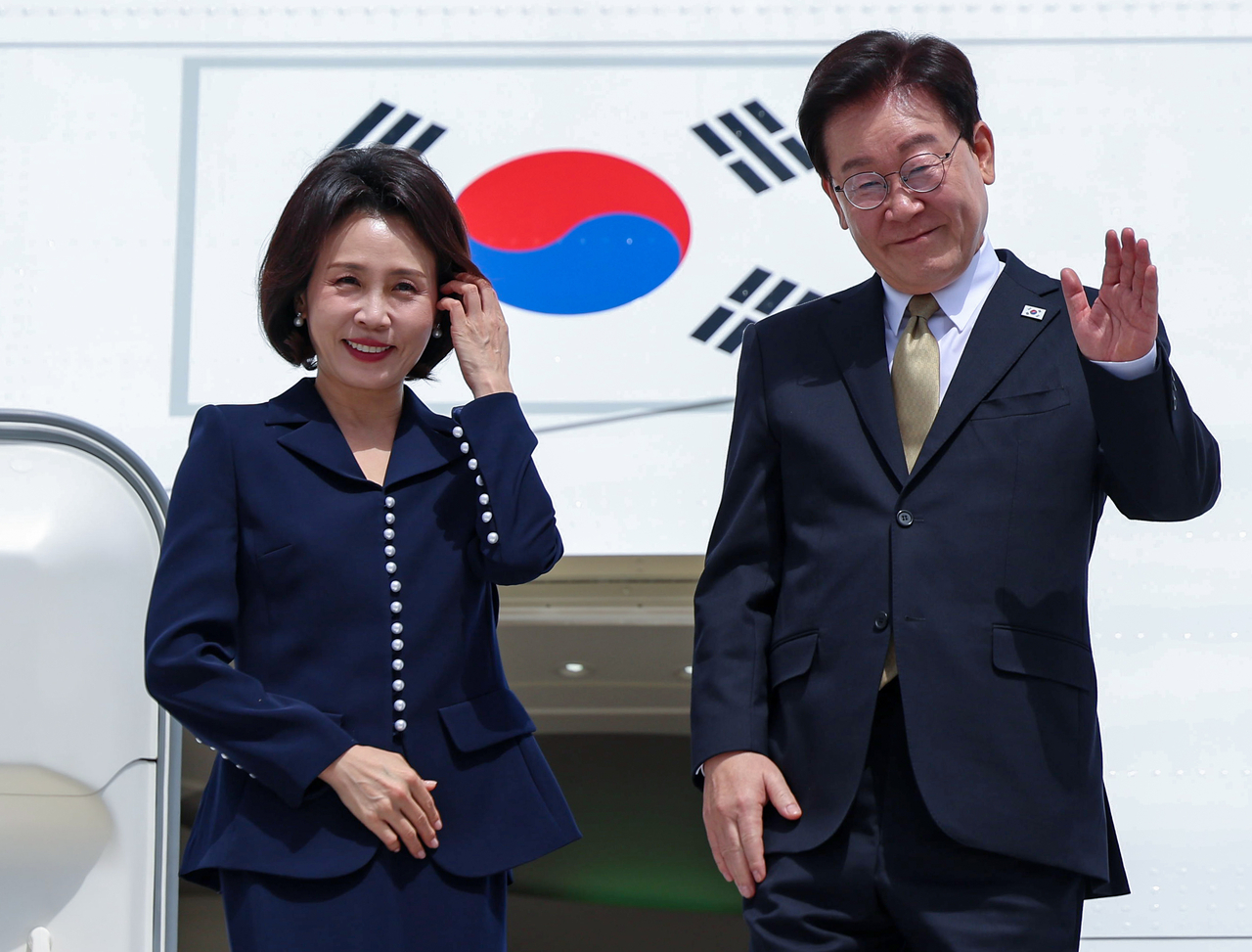 President Lee Jae Myung (R) and first lady Kim Hea Kyung wave before boarding the presidential plane at Felipe Angeles International Airport in Mexico City following a state visit to Mexico on Saturday. (Yonhap)