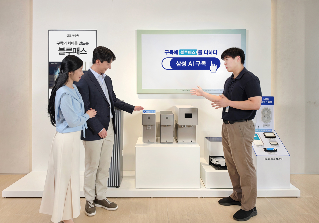 A Samsung Electronics employee (right) explains the company's AI appliance subscription service to customers at Samsung Store Cheongdam in Seoul. (Samsung Electronics)